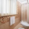 Bagno con doccia angolare e piastrelle a mosaico.