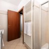 Bagno con doccia, lavandino e porta in legno.