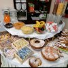 Buffet con dolci, frutta, succhi, e cereali. Tavolo ben imbandito.