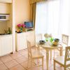 Cucina bianca con tavolo apparecchiato vicino a grandi tende.