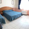 Camera d'albergo con due letti singoli blu.