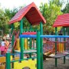 Area giochi all'aperto con strutture colorate per bambini e persone.