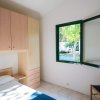 Camera con letto, armadio e finestra aperta.