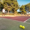 Uomo che gioca a tennis su un campo all'aperto.