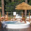 Persone rilassate in una vasca idromassaggio all'aperto su una terrazza in legno.