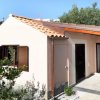 Bungalow con tetto in tegole e giardino.