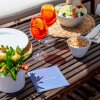 Tavolo con bevande arancioni, insalata, snack, e decorazioni.