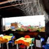 Terrazza con tavoli colorati che si affaccia sul mare e un'area giochi gonfiabile.