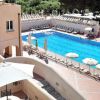 Piscina all'aperto con lettini e ombrelloni bianchi.