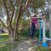 Due donne fanno esercizio all'aperto con attrezzi fitness.