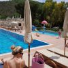 Una piscina con lettini e ombrelloni, persone che si rilassano.