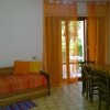 Sala con divano arancione e tavolo da pranzo vicino alla finestra.