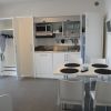 Cucina moderna con tavolo da pranzo e sedie bianche.