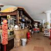 Un bar con bancone in pietra, espositore di bibite e una tavola da surf appesa.
