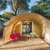 Tenda a cupola con sedie e tavolino su una pedana in legno.