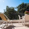 Terrazzino con sedia a sdraio e tavolo bianco.