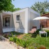 Una casa moderna con prato, ombrellone e fiori.